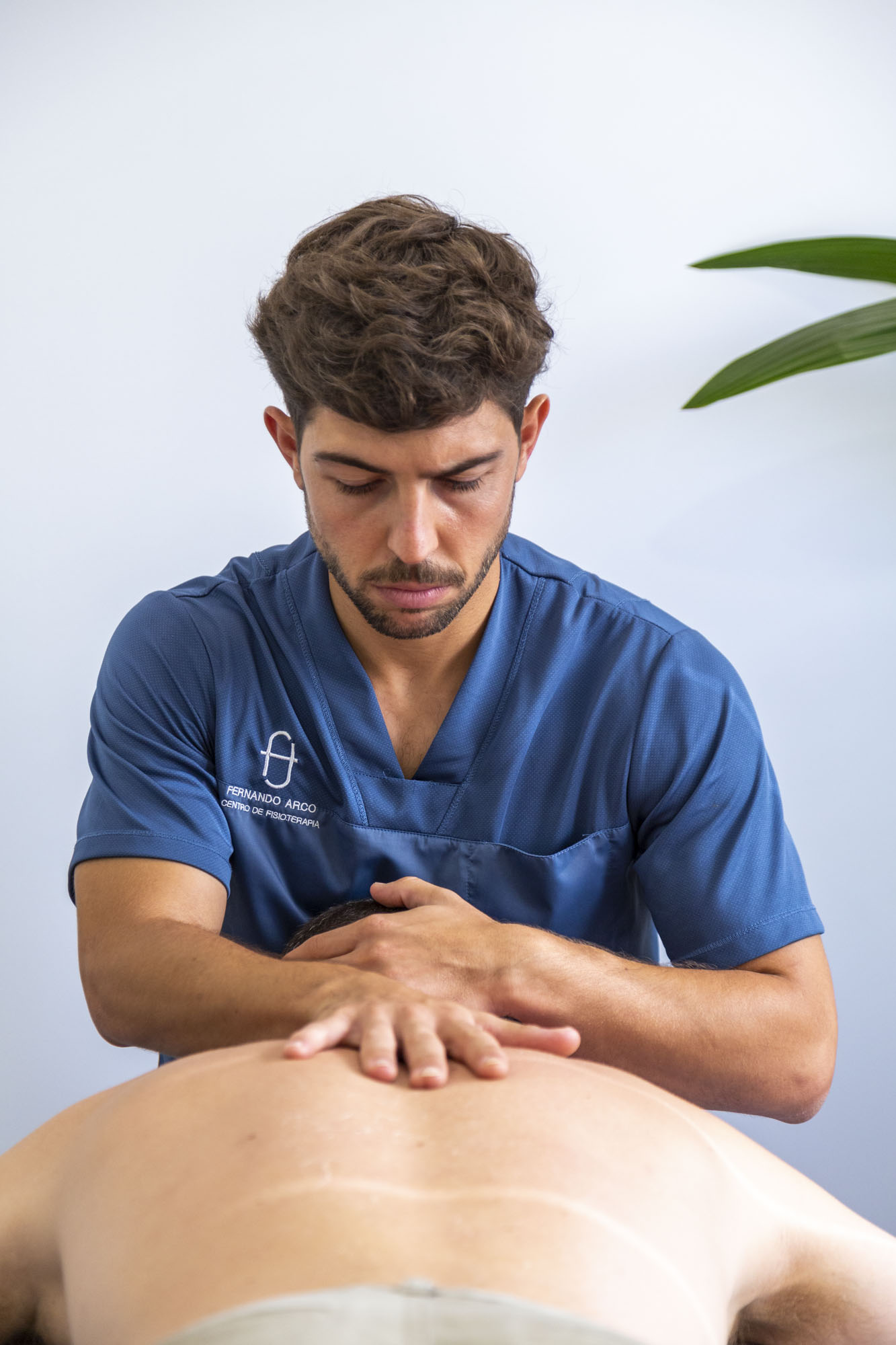 Fisioterapeuta Fernando Arco realizando un trabajo de masaje abdominal a un paciente tumbado en la camilla en Centro de fisioterapia almeria Fernando Arco