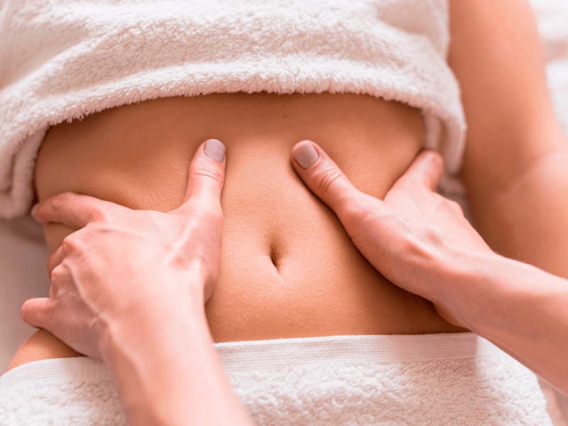Manos de fisio Fernando Arco Fisioterapia realizando masaje de suelo pelvico a mujer de blanco