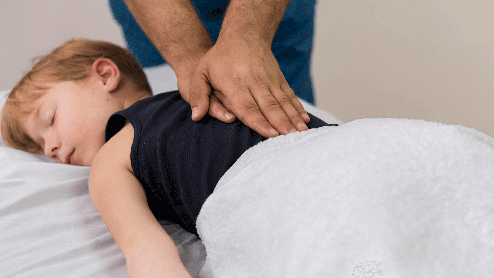 Niño tumbado en camilla recibe tratamiento de fisioterapia pediátrica en Fernando Arco Centro de Fisioterapia en Almería