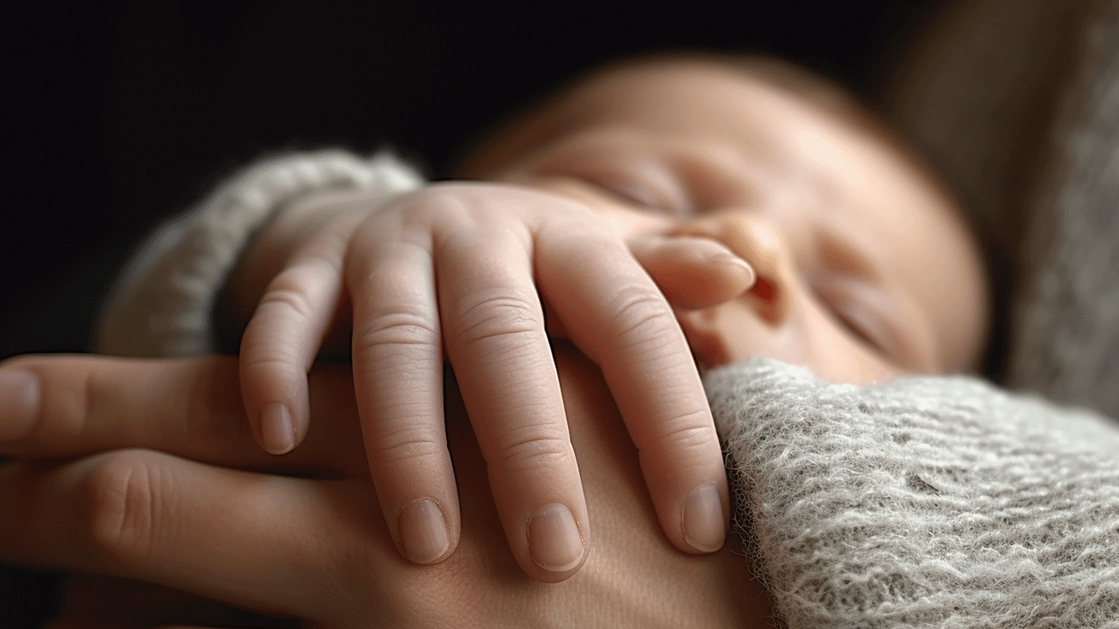 como la fisioterapia mejora la lactancia materna mano de bebe dormido sobre su madre con fondo negro en Fernando Arco Centro de Fisioterapia en Almería
