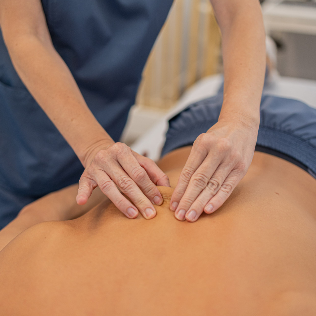 Tratamiento Miofascial para Aliviar Dolor Muscular en Almería – Fernando Arco Manos de terapeuta aplicando tratamiento miofascial en paciente en clínica Fernando Arco, Almería