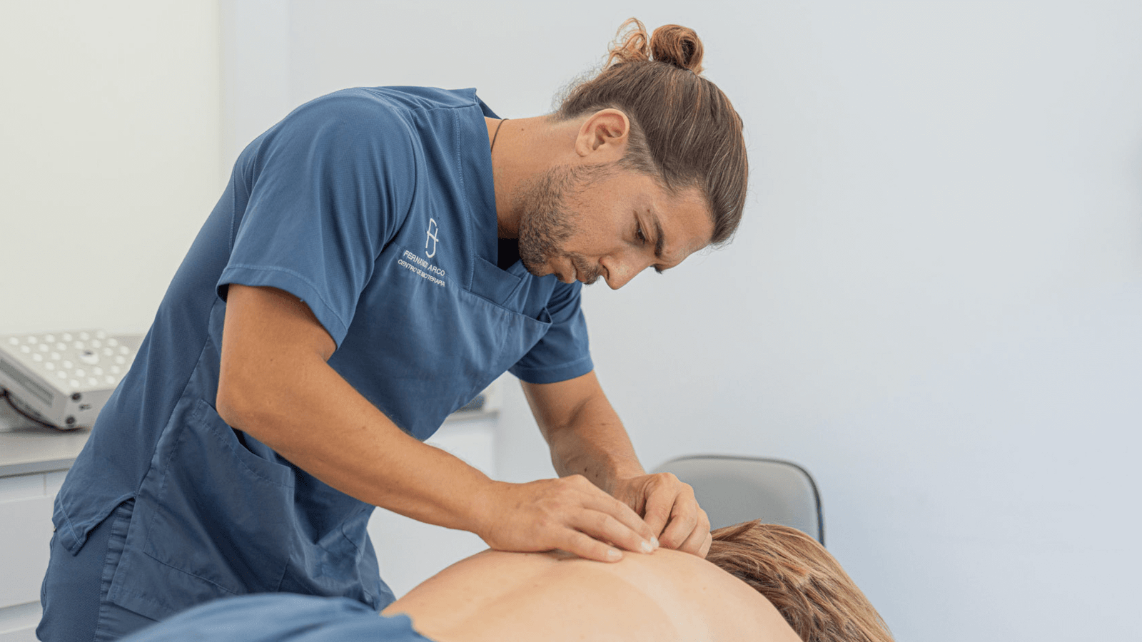 b Fernando Arco aplicando una técnica de fisioterapia en la espalda de una paciente en su centro de Almería.