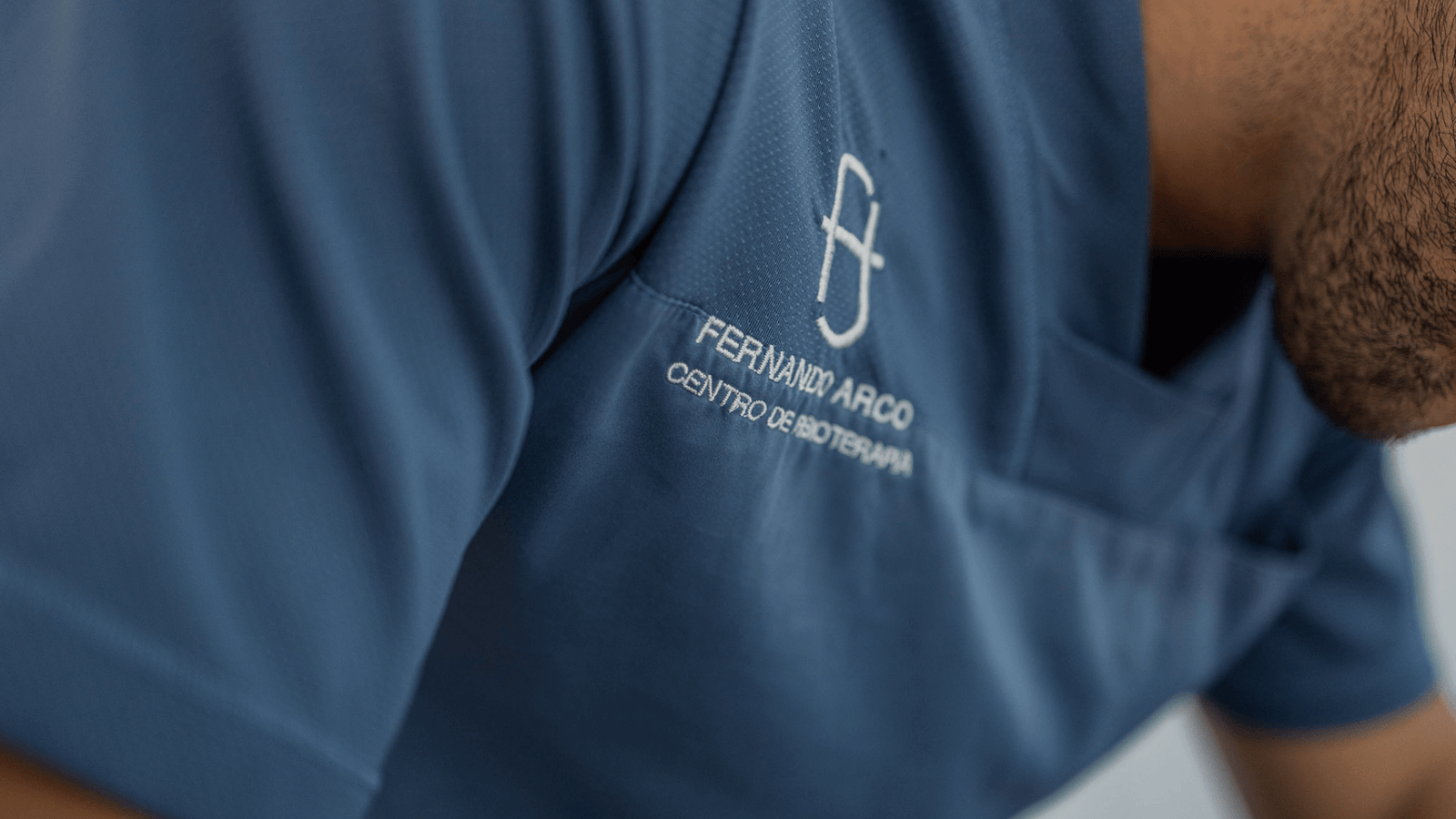 Fernando Arco Fisioterapia: Profesionalidad y Compromiso Detalle del logo "Fernando Arco Centro de Fisioterapia" bordado en el uniforme profesional del equipo.